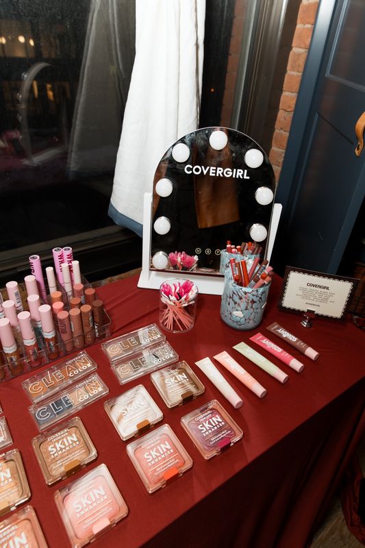 COVERGIRL beauty activation at ISR’s Social Impact House anniversary featuring makeup, lip products, and a lighted mirror.