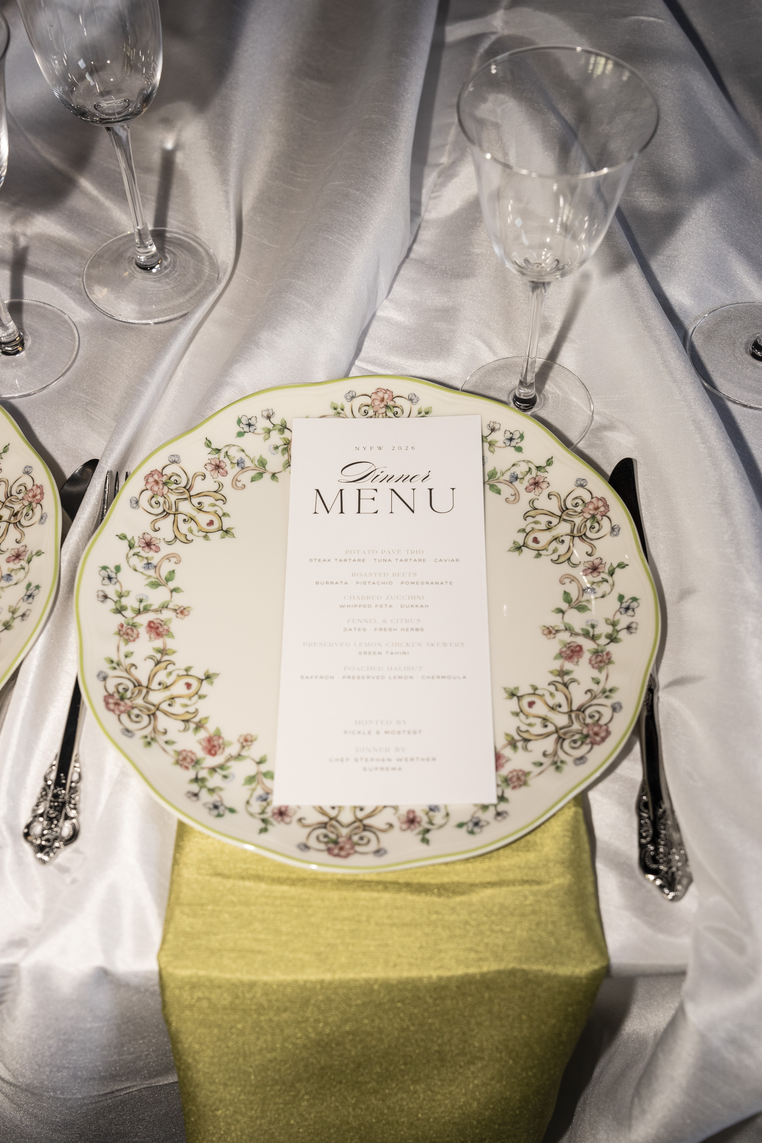 Floral dinner plate and custom menu on a green-and-white tablescape at the Pickle x Mostest NYFW kickoff dinner.