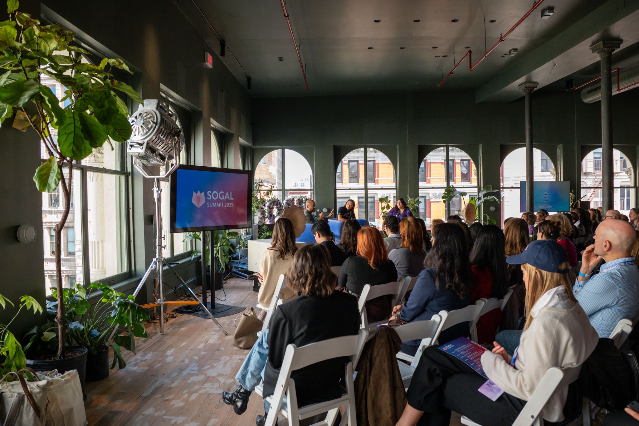 Audience watching a panel discussion at SoGal Summit 2025 in a bright SoHo event space.